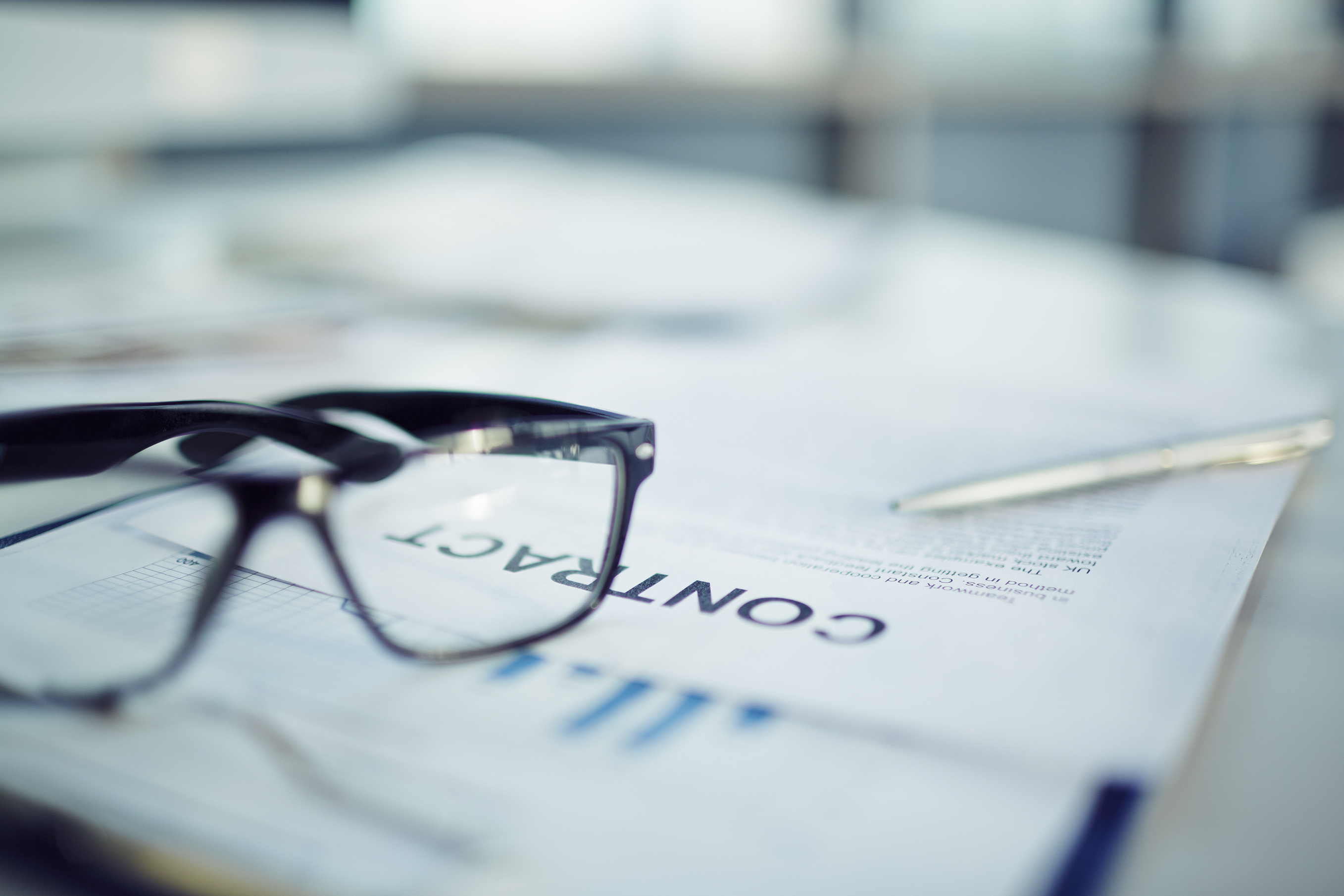 Close-up of business documents with glasses on the table