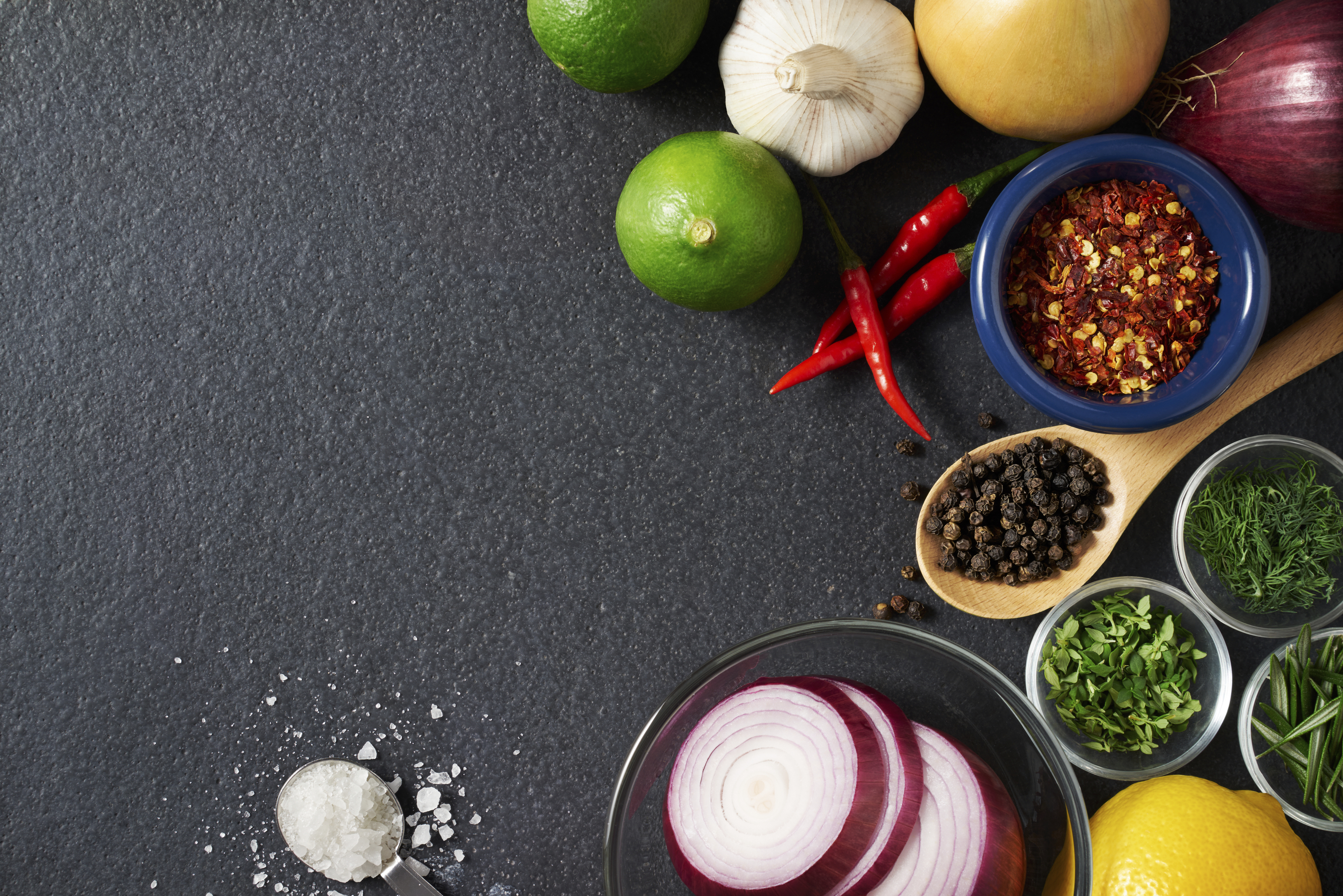 Spices and food ingredients on slate background with copy space